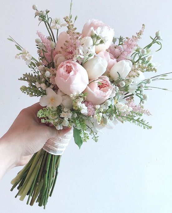 a spring wedding bouquet of white tulips, pink peonies and astilbe, greenery and fillers is a very delicate and tender idea