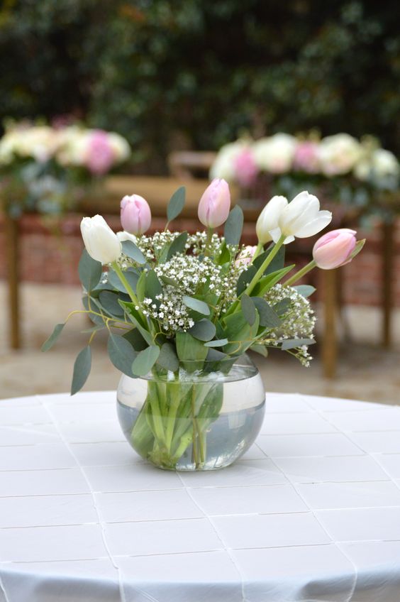 a spring wedding centerpiece of pink and white flowers and some greenery and fillers is a cool idea for the season