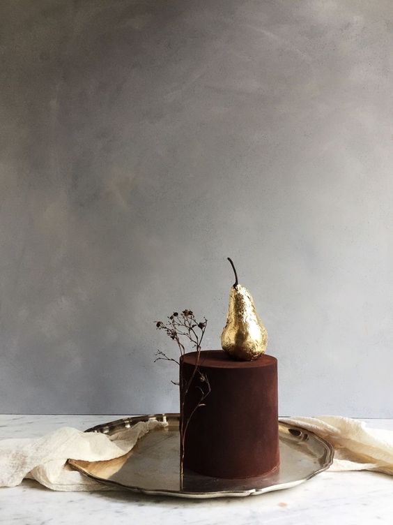a statement fall wedding cake, a matte chocolate one with a gilded pear and a branch is a unique idea