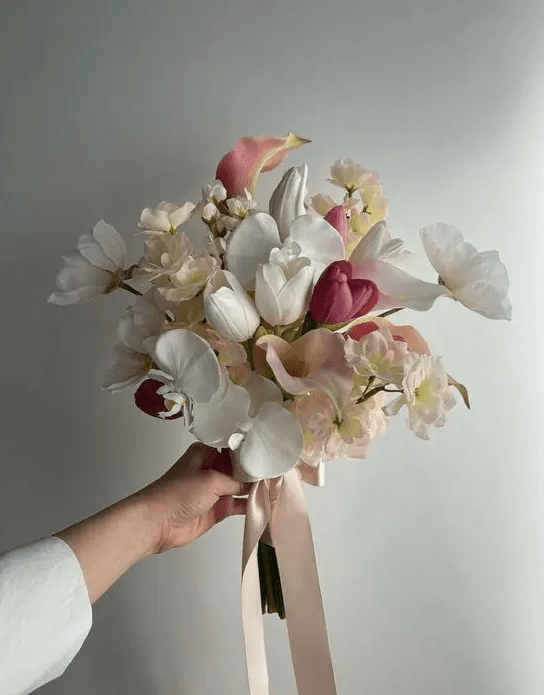 a stylish modern wedding bouquet of white and purple tulips, white orchids, pink callas and sweet peas is amazing for spring