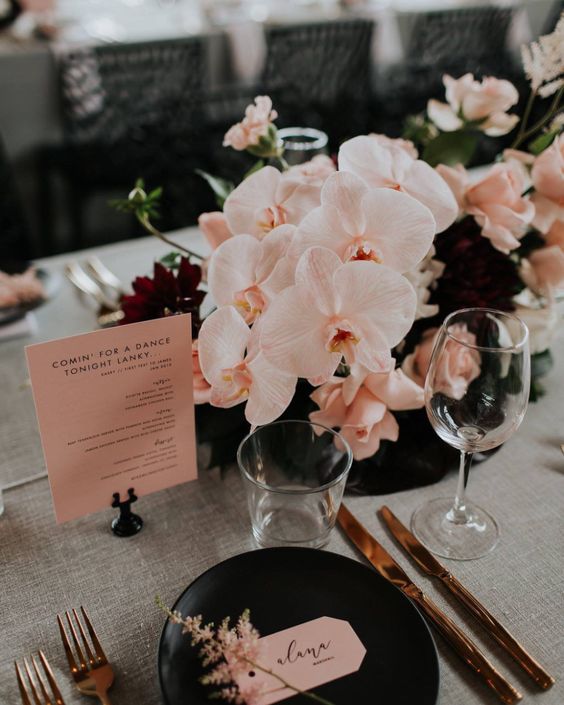 a stylish modern wedding centerpiece of burgundy roses and blush roses and orchids is an adorable idea