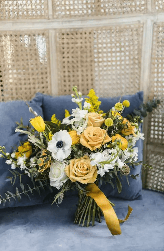 a stylish wedding bouquet with billy balls, yellow tulips and mimosas, white anemone sand roses plus euclalyptus