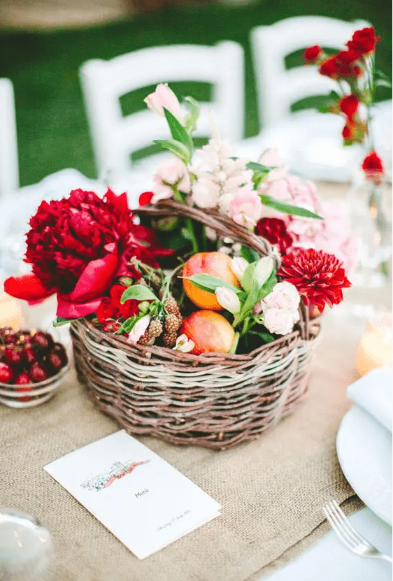 a summer basket wedding centerpiece with fruit and flowers is a lovely idea, and you can make one yourself