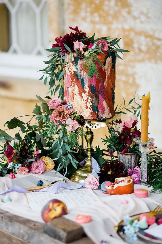 a super bold painted tall wedding cake with pink, burgundy and fuchsia blooms and greenery is amazing for a colorful wedding