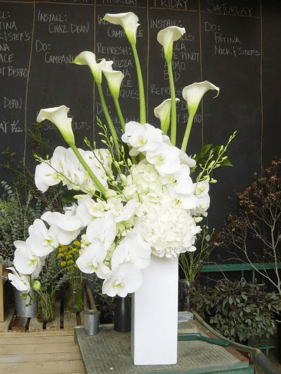 a tall wedding centerpiece of white hydrangeas, callas and orchids is a stylish and catchy idea for a modern neutral wedding