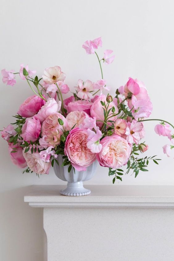 a tender pink wedding centerpiece of peony roses and some greenery is fantastic for a spring wedding