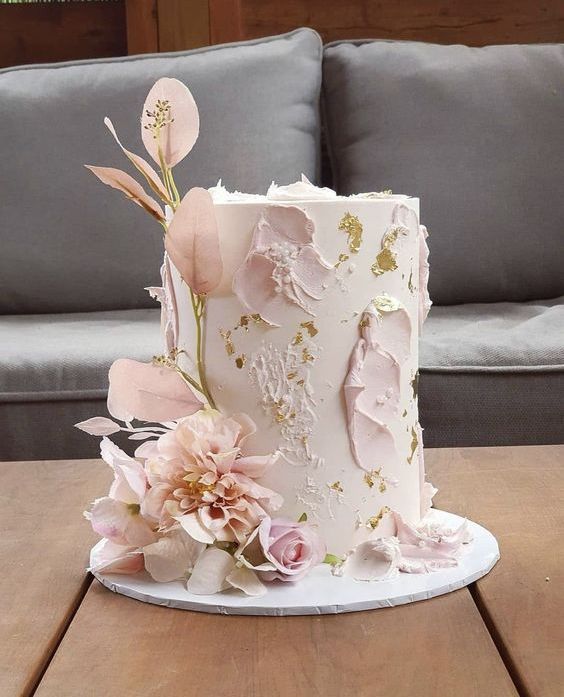 a textural blush wedding cake with painted blooms, gold leaf, blush bloomsand leaves is a chic idea for spring