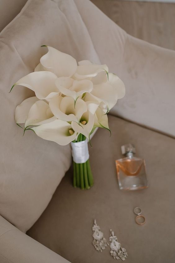 a white calla bouquet with a white wrap is a classic idea for a modern or minimalist bride