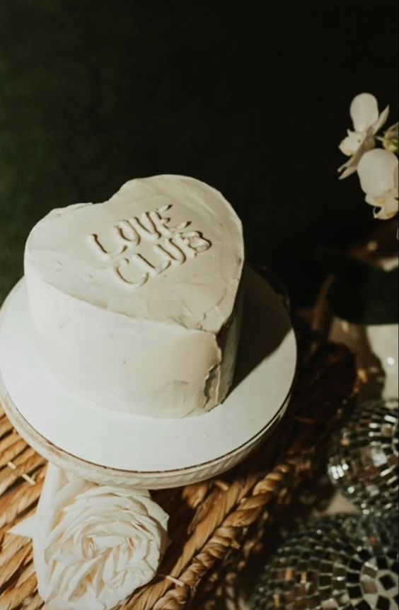 A white heart shaped wedding cake with letters is a lovely idea  for a modern wedding