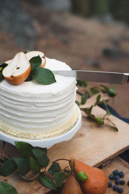 a white textured wedding cake topped with fresh leaves and pears is a chic and refined idea for a fall wedding