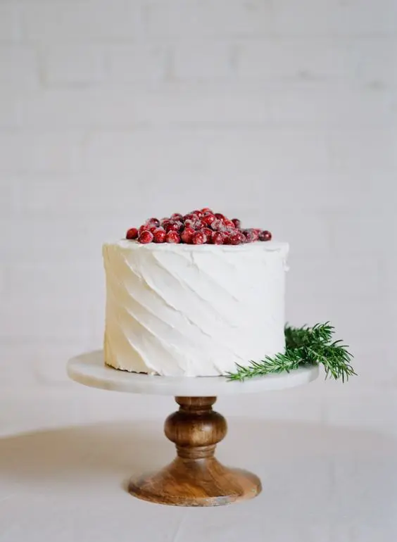a white textured wedding cake with fresh cranberries on top is a cool idea for a winter or Christmas wedding