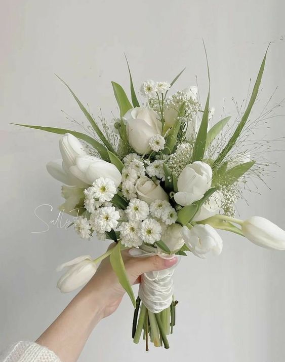 an airy spring wedding bouquet of tulips, little mums, greenery and some fillers is a cool idea for the season, for a neutral wedding