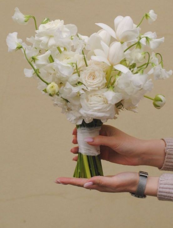 an ethereal white wedding bouquet of roses, tulips and sweet peas is a cool and chic idea for a spring or summer bride