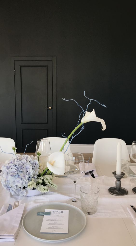 An ikeabana style wedding centerpiece of white callas, light blue hydrangeas and some twigs is a chic and cool solution