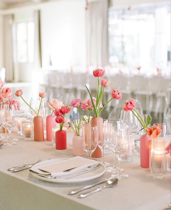 cluster wedding centerpiece of blush, light pink and red vases and pink, blush and red tulips of various kinds