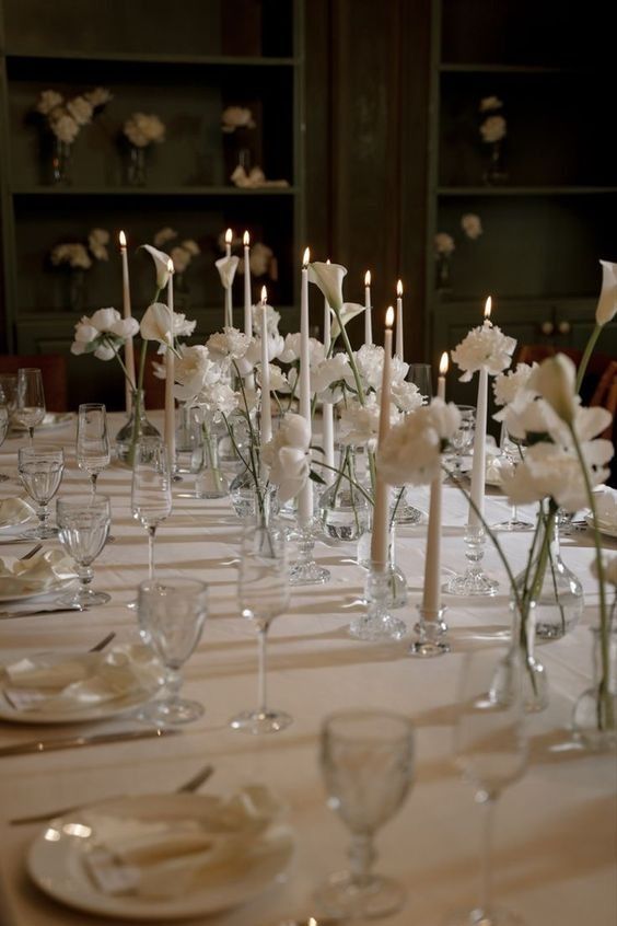 cluster wedding centerpieces of white roses, carnations, callas and tall and thin candles are gorgeous for a modern wedding