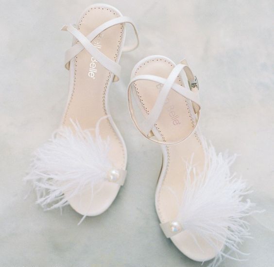 delicate white strappy heels with feathers with criss cross straps are amazing for a glam bridal look