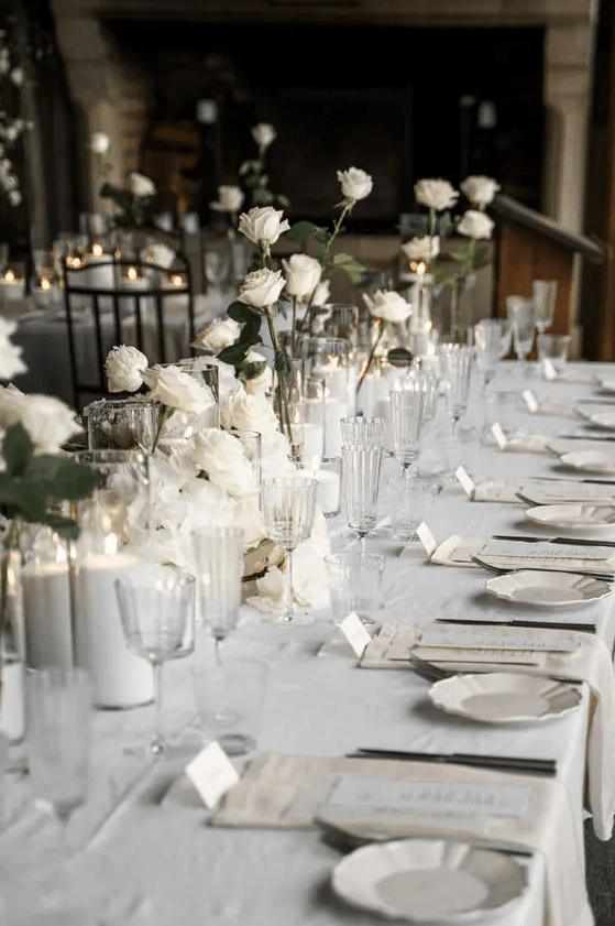 minimalist white wedding centerpieces of roses and pillar candles are amazing for a minimalist wedding