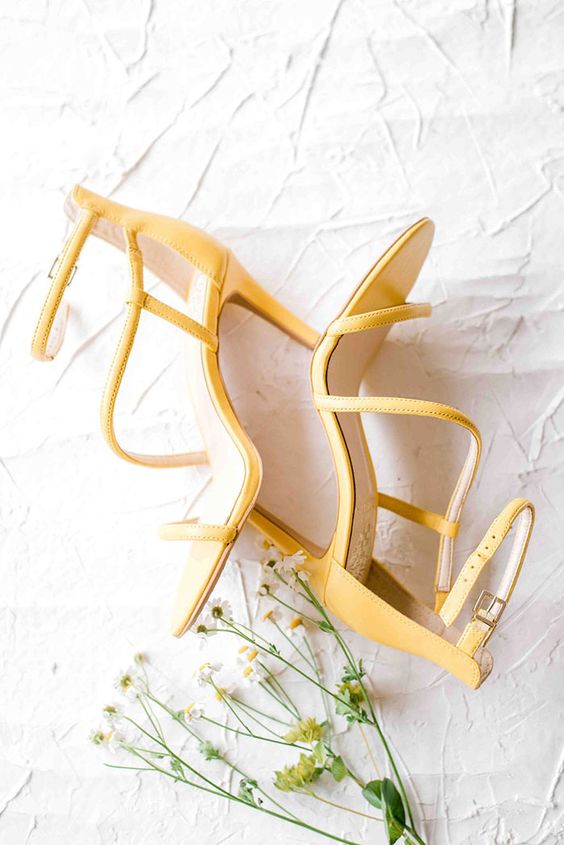 Minimalist yet eye catchy yellow  wedding shoes with thin straps and high heels for a spring or summer bridal look