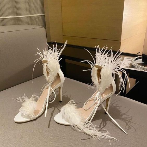 neutral wedding shoes with feathers and straps are a cool idea for a modern and glam bridal look