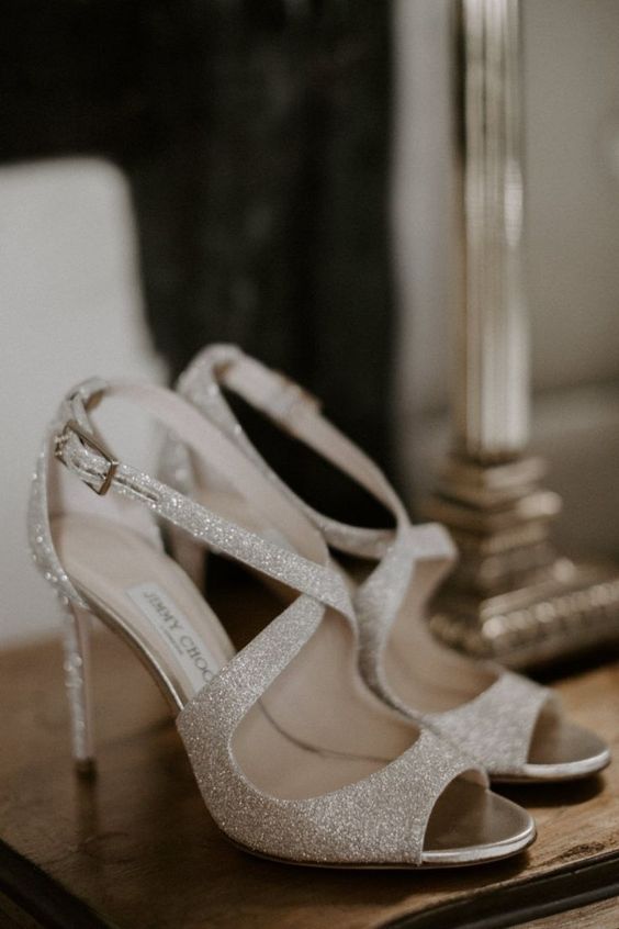 shiny and glam silver bridal shoes with criss cross straps and high heels are amazing for a glam bridal look