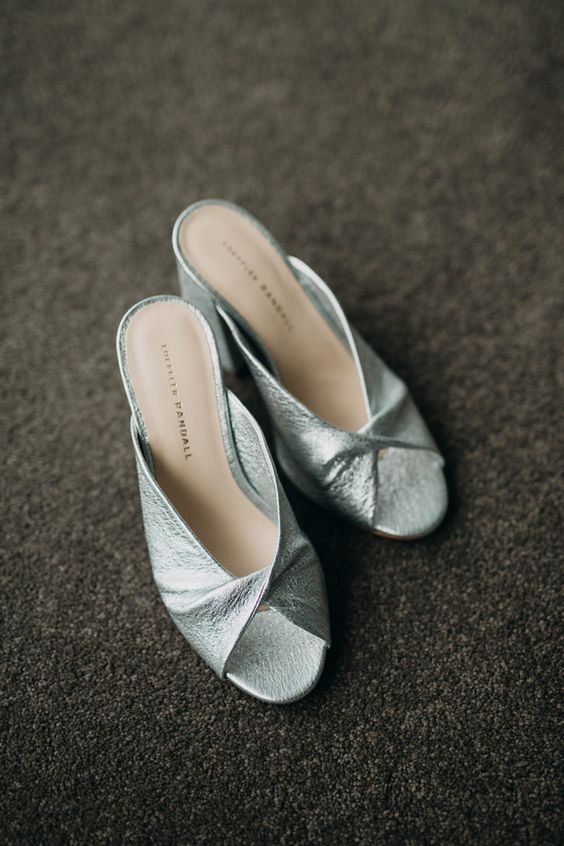 Silver wedding mules with twisted tops will be a comfortable solution for a bride, they look bold and very eye catchy
