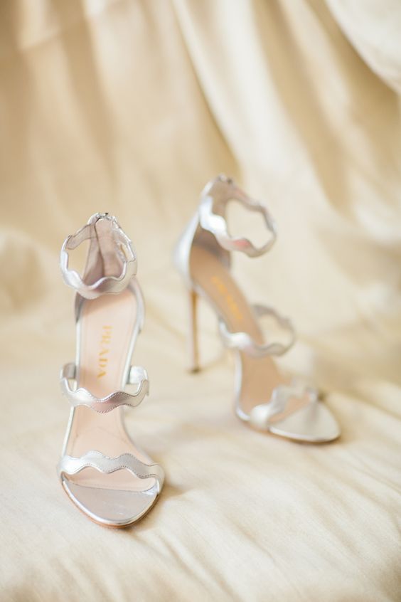 silver wedding shoes with wavy straps and high heels are a cool and catchy idea for those brides who want high heels