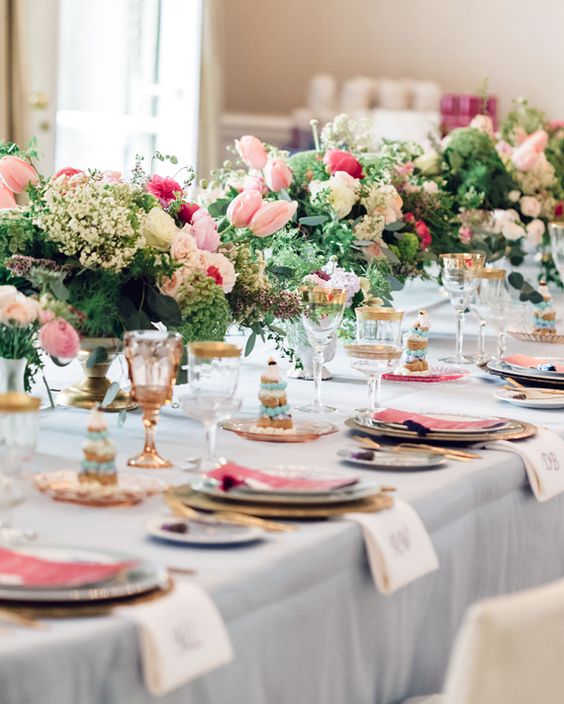 summer wedding centerpieces of lush greenery, white fillers, pink tulips and hot pink roses are gorgeous for summer