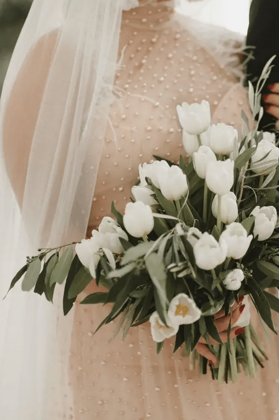 this simple and sweet white tulip wedding bouquet sprueced up with greenery is a dreamy idea for a spring bride