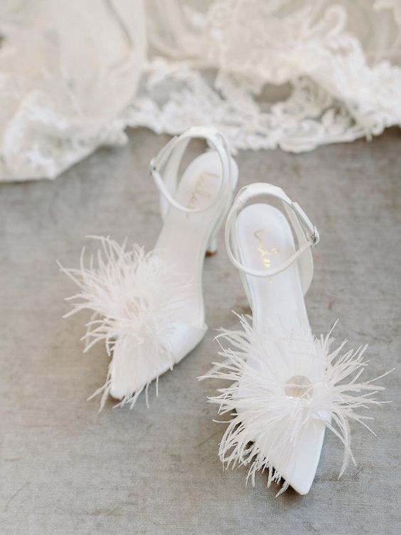 white pointed toe wedding shoes with feathers and ankle straps are a fashionable idea for a wedding