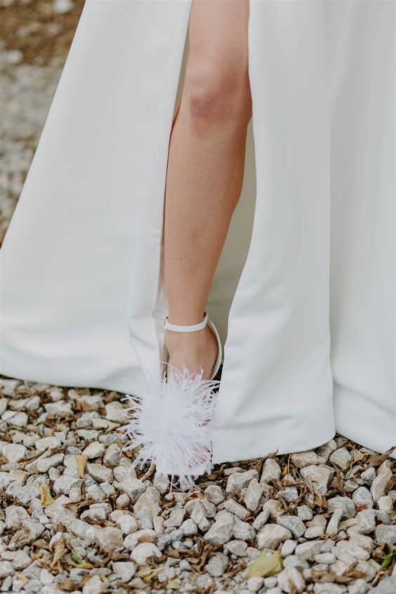 white wedding shoes with feathers and ankle straps are amazing for a modern and chic bridal look
