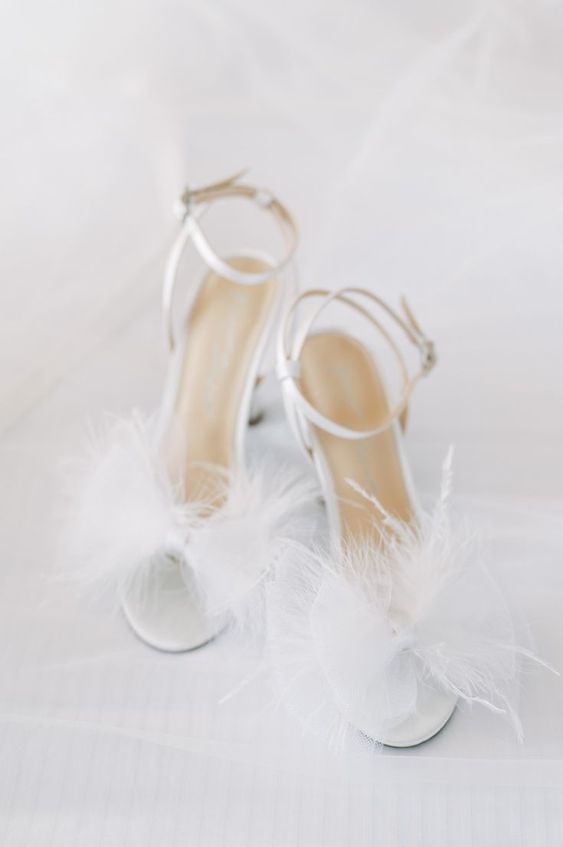 white wedding shoes with feathers and ankle straps are amazing for a modern bridal look in spring or summer