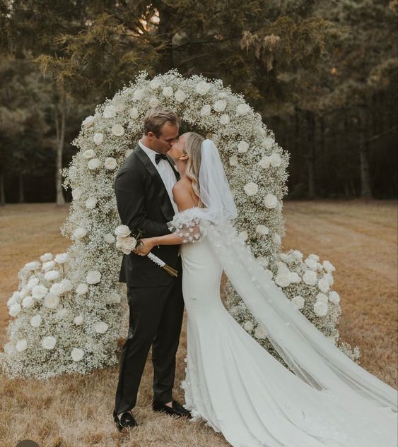 a wedding arch done with white baby’s breath and roses is a chic and stylish idea for a spring or summer wedding
