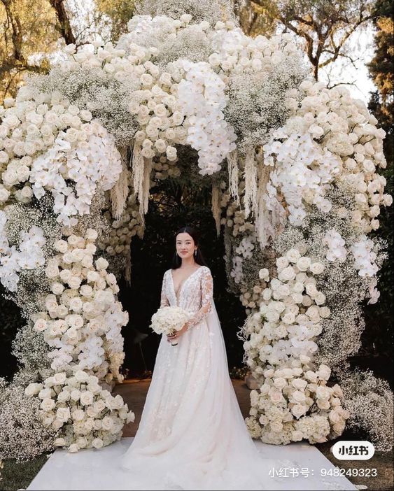 a super lush and refined wedding arch covered with roses, baby’s breath, amaranthus and orchids is a very chic and exquisite idea