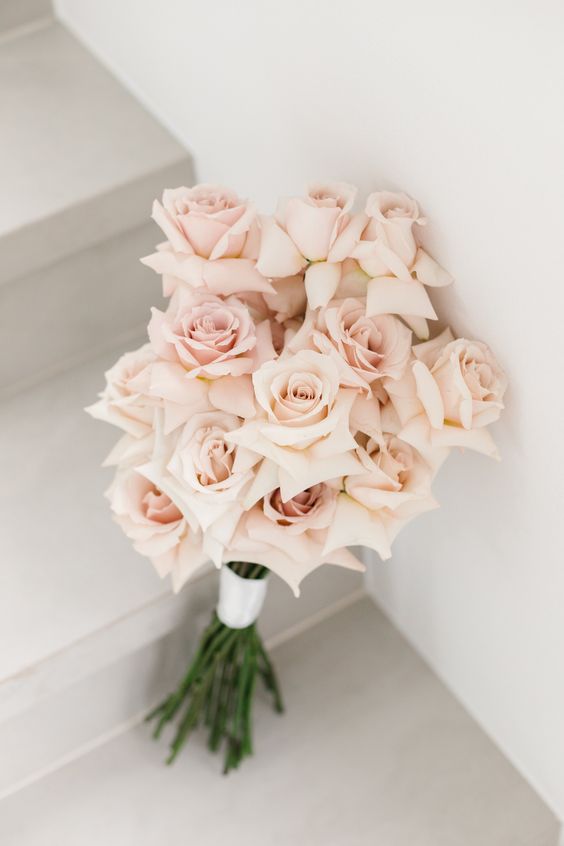 a beautiful and delicate long stem blush rose wedding bouquet is a very modern and refined idea for a bride who wants a tender arrangement