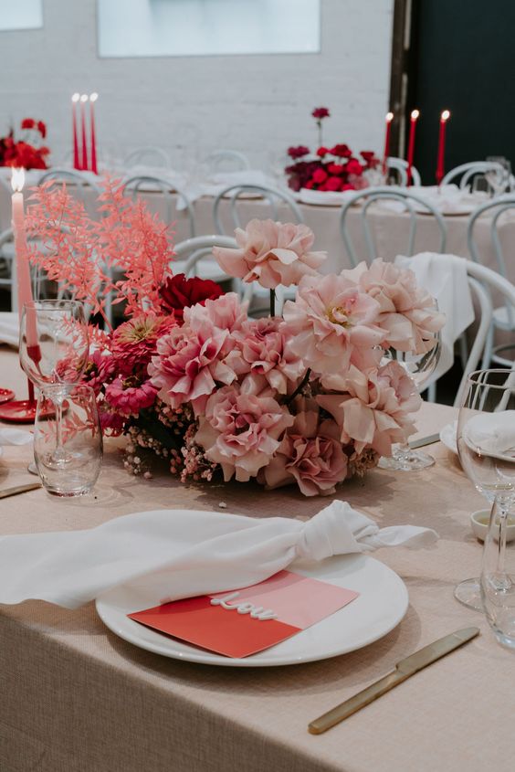 a beautiful modern wedding centerpiece of blush and pink roses, some dahlias, baby’s breath and dried leaves is adorable