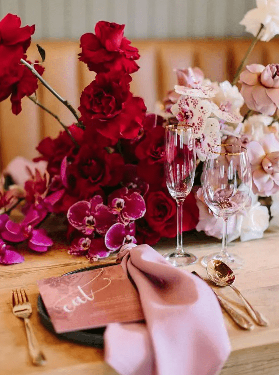 a beautiful wedding centerpiece from hot pink to red and blush, completely of orchids is a very refined idea