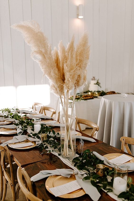 a boho wedding centerpiece of a clear vase with pampas grass is a lovely boho decoration, you can easily make one yourself