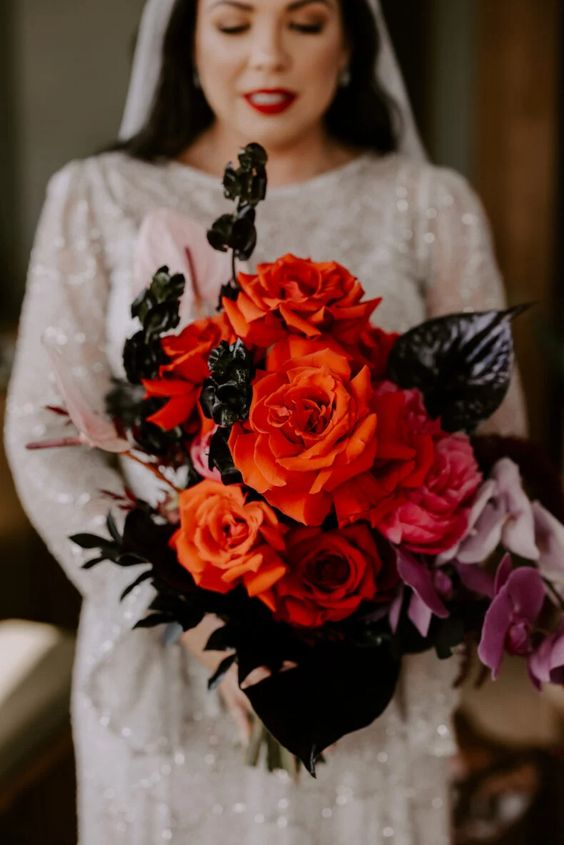 a bold Halloween wedding bouquet of red roses, pink orchids and deep purple anthuriums is super cool and catchy