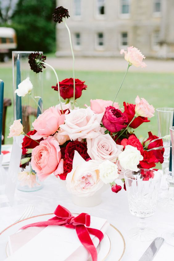 a bold and chic rose wedding centerpiece of blush, pink and red roses and some peonies and mums is amazing for a catchy wedding