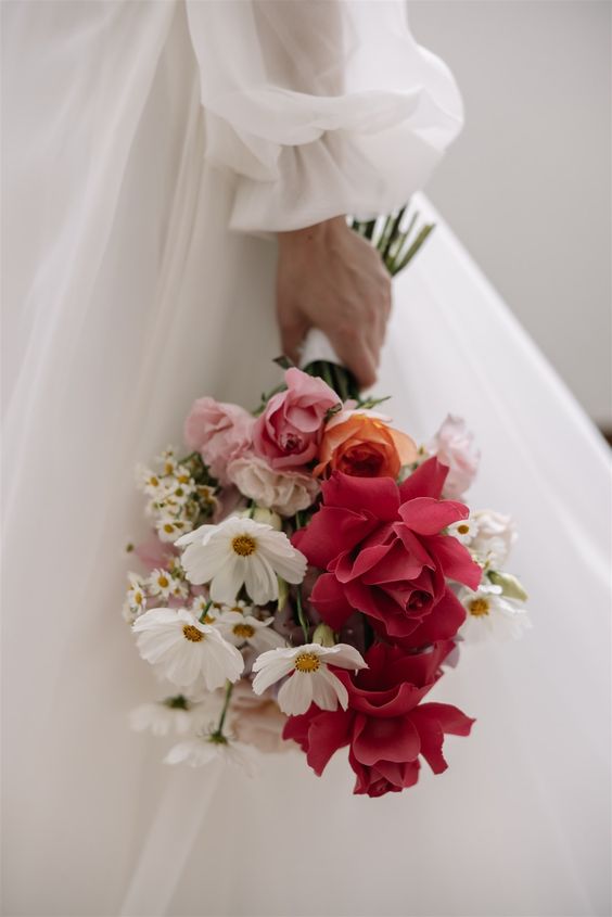 a bold modern wedding bouquet of white cosmos and chamomiles, pink and large red roses is a gorgeous solution