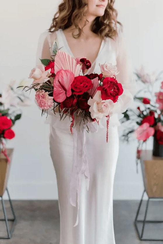 a bold pink wedding bouquet of anthurium, roses and carnations, pink fronds and ribbons is a cool idea for a colorful wedding