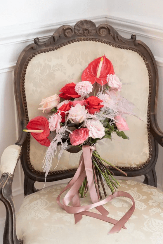 a bold wedding bouquet of blush and light pink roses and mums, red roses and anthurium plus blush grasses is a lovely idea