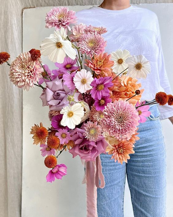 a bold wedding bouquet of pink and white cosmos, pink and orange dahlias and some pink roses is cool