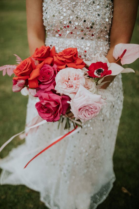 a bold wedding bouquet of red, pink and blush roses, red anemones and pink anthuriums is adorable and extra bold