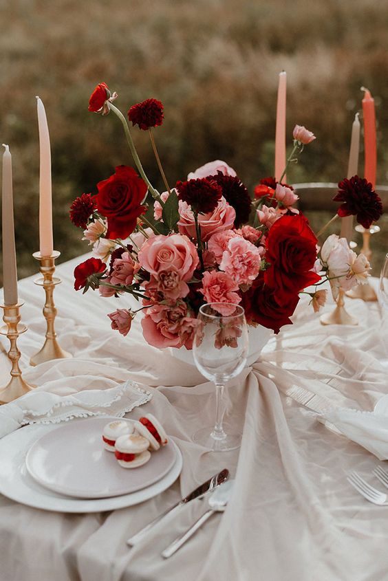 a bold wedding centerpiece of pink and burgundy roses is a very eye-catchy idea for a summer or fall wedding