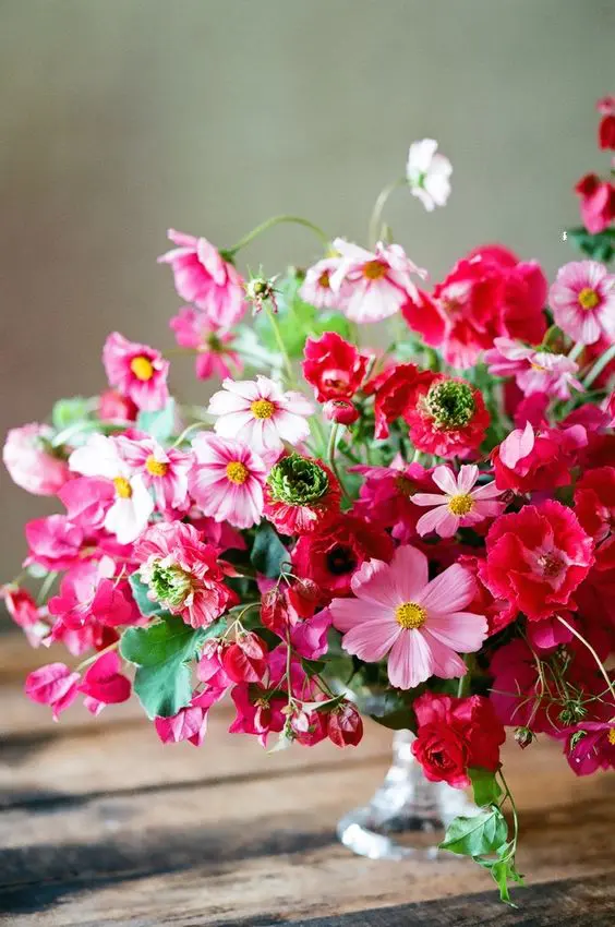 a bold wedding centerpiece of pink cosmos and bouginavillea is amazing for a bright summer wedding