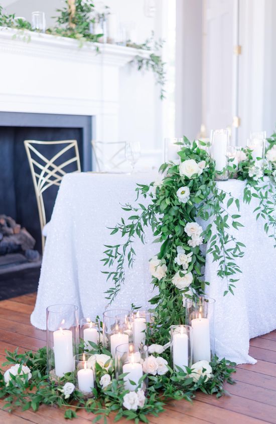 a cascading greenery and white anemone wedding centerpiece with a lot of candles is always a good idea for a wedding