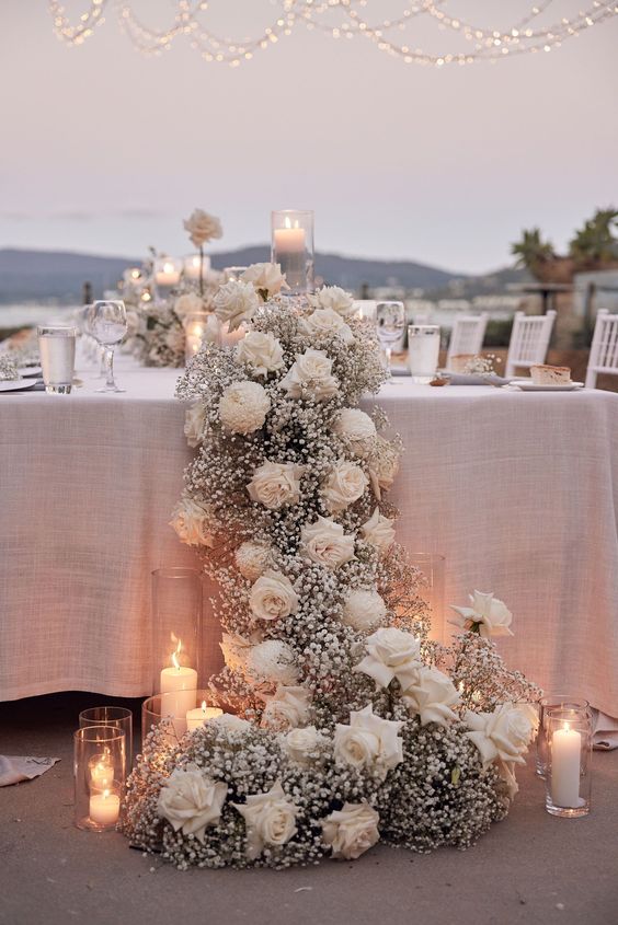 a cascading wedding centerpiece of white roses and baby’s breath is a lovely idea for a refined neutral wedding, add candles for more chic