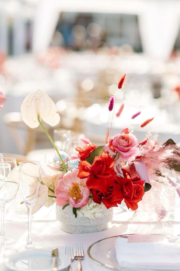 a catchy modern wedding ombre centerpiece from blush to pink and red, with roses, peonies and grasses